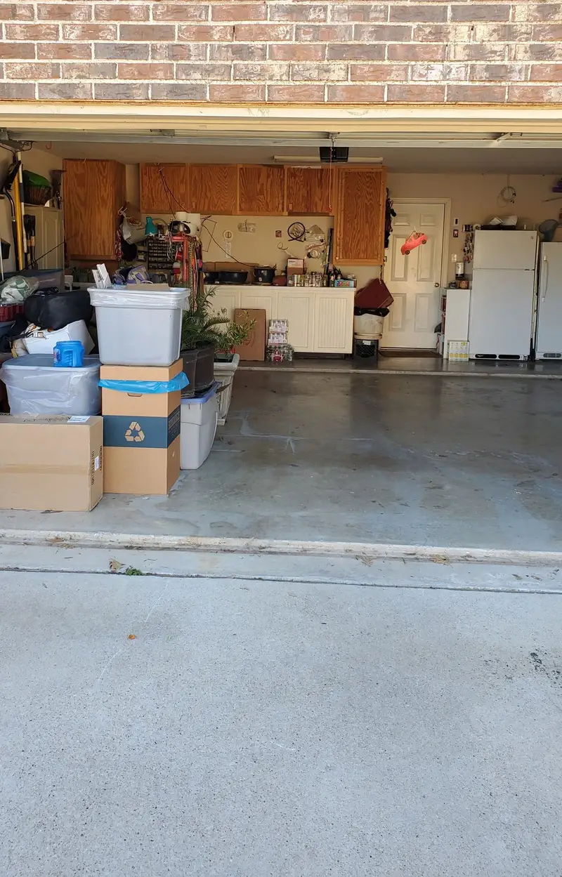 Garage with stored boxes, bins and appliances